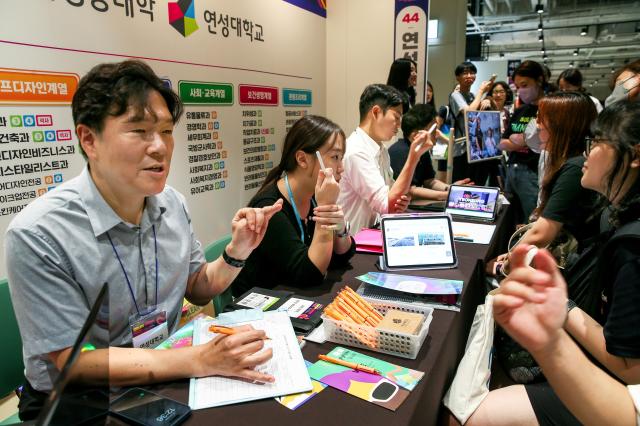 Booth representatives explain admission procedures at the 2025 College Rolling Admission Fair at COEX in Seoul on Sept 20 2024 AJP Kim Dong-woo