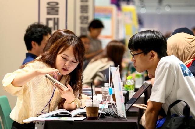 A booth representative explains admission procedures at the 2025 College Rolling Admission Fair at COEX in Seoul on Sept 20 2024 AJP Kim Dong-woo