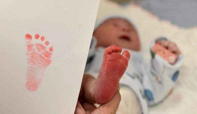 A healthcare worker takes a commemorative footprint of a newborn baby at a hospital in Shijiazhuang Hebei Province northern China on January 22 2023 Xinhua-Yonhap