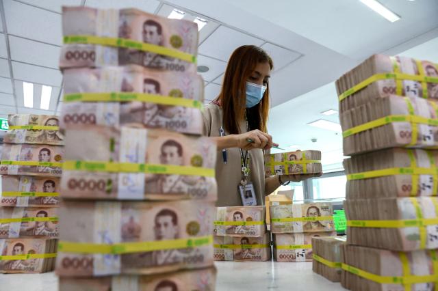 A Thai bank employee gathering Thai baht notes in Bangkok Thailand January 26 2023 REUTERS-Yonhap