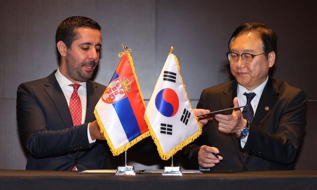 This photo shows Koreas Minister of Trade Cheong In-kyo right and Serbian Minister of Domestic and Foreign Trade Tomislav Momirović exchanging papers they each signed concerning the commencement of negotiations for an economic partnership agreement EPA between the two nations Seoul Sept 26 2024 Yonhap
