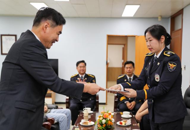 조상명 국정상황실장이 27일 충북 충주시 중앙경찰학교에서 윤석열 대통령이 준비한 축하 서한과 선물을 윤은정 순경에게 전달하고 있다 사진연합뉴스