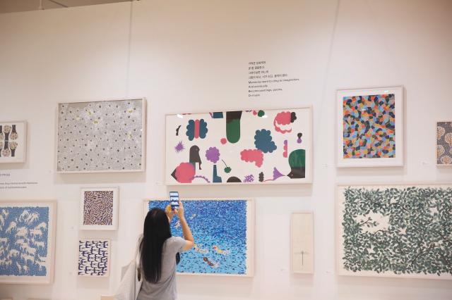 A visitor takes a photo of exhibits at the minä perhonen exhibition held at DDP in Seoul on Sept 27 2024 AJP Han Jun-gu