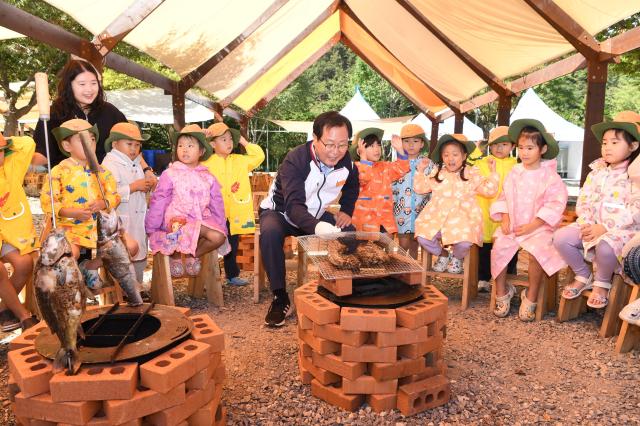 완주군의 대표축제인 ‘완주 와일드로컬푸드축제’가 이달 4일부터 6일까지 고산자연휴양림 일원에서 개최되는 가운데 유희태 군수가 아이들과 함께 물고기를 구워먹고 있다사진완주군