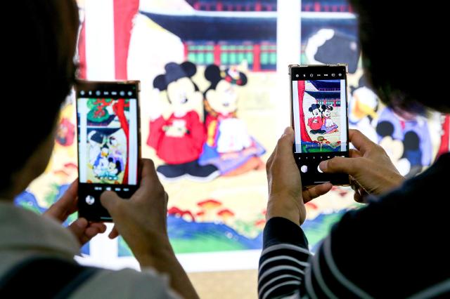 Visitors take photos at the MickeyFriends Seoul Tour exhibition at Deoksugung Palace in Jung-gu Seoul on Oct 4 2024 AJP Kim Dong-woo