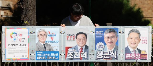 3일 오전 서울 종로구 동숭동 예술가의집 담장에 서울시선거관리위원회 관계자들이 서울시교육감 보궐 선거 벽보를 붙이고 있다 2024103 사진연합뉴스
   