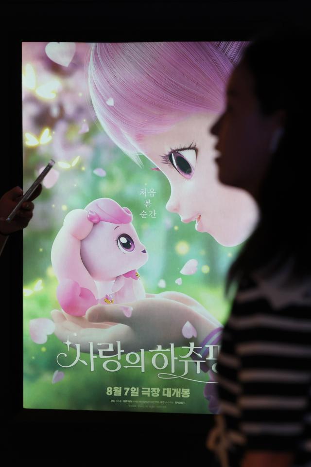 People passing by a poster of the childrens animation movie Heartsping Teenieping of Love in Yongsan Seoul Sept 18 2024 Yonhap