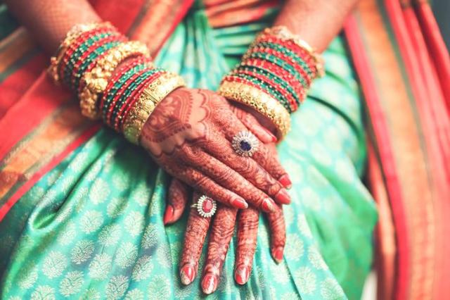 This photo features an Indian brides hands adorned with jewelry Getty Images Bank