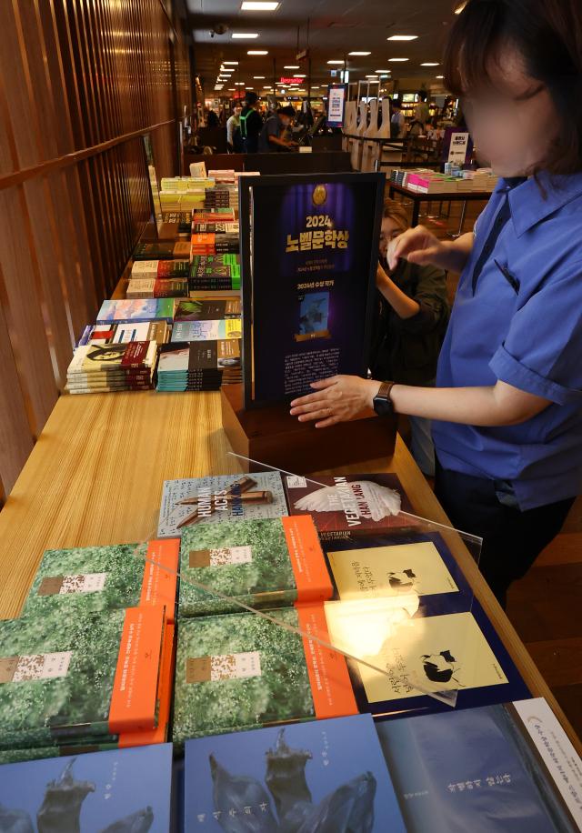 An employee of Kyobo Bookstore in central Seoul is busy setting up a special display for books written by South Korean author Han Kang after she was announced as the winner of this years Nobel Prize in Literature Oct 10 2024 Yonhap