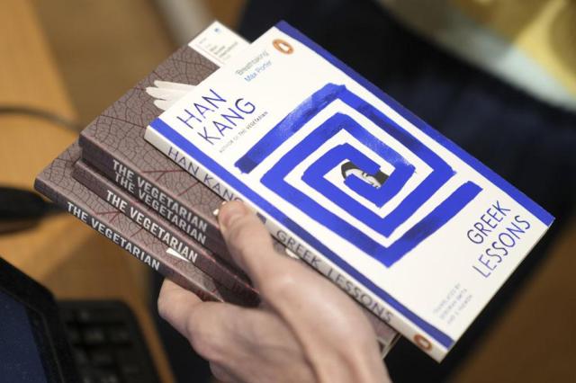 A book store employee handles books by the South Korean writer Han Kang in London on Oct 10 2024 AP-Yonhap