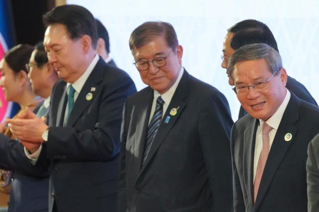 Japanese Prime Minister Shigeru Ishiba middle stands between South Korean President Yoon Suk Yeol left and Chinese Premier Li Qiang right at the Association of Southeast Asian Nations ASEAN Plus Three Summit in Vientiane Laos Oct 10 2024 AP-Yonhap