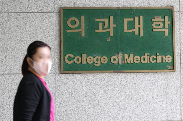 22일 오전 서울 시내 한 의과대학에서 한 시민이 의과대학 간판을 지나치고 있다 2024922 사진연합뉴스
    