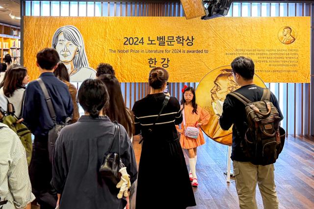 Visitors take photos at a special display celebrating Han Kangs Nobel Prize in Literature win at Kyobo Bookstore in Seoul on Oct 12 2024 AJP Kim Dong-woo