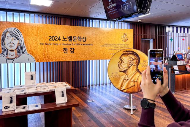 A visitor takes a photo at a special display celebrating Han Kangs Nobel Prize in Literature win at Kyobo Bookstore in Seoul on Oct 12 2024 AJP Kim Dong-woo