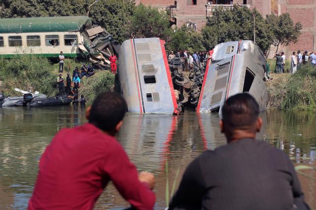 People gather near the wreckage after a locomotive collided in southern Egypt on Oct. 13, 2024.