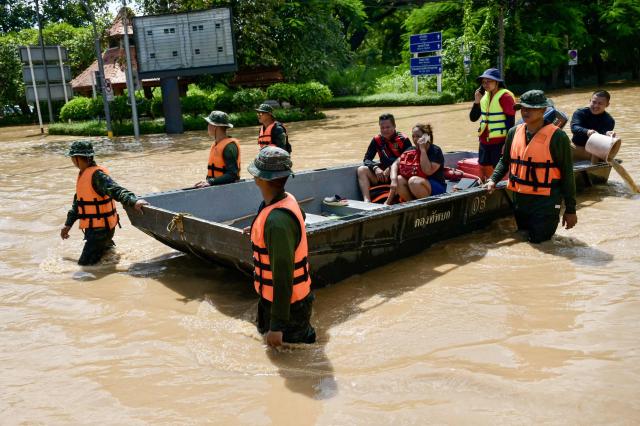 Rescue officials evacuate residents affected by flooding in a boat in Chiang Mai on October 6 2024 AFP-Yonhap