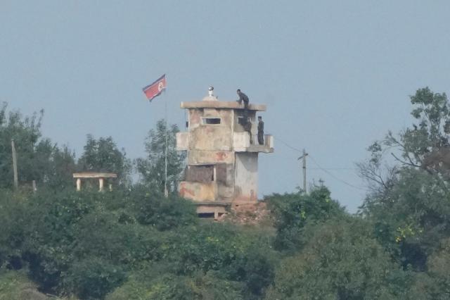 North Korean soldiers work at the Norths military guard post as a North Korean flag flutters in the wind are seen from Paju South Korea near the border with North Korea Oct 10 2024 AP-Yonhap