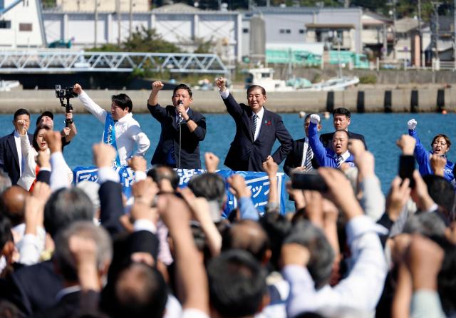 Japanese Prime Minister Shigeru Ishiba center holds his fist high after his stump speech for a ruling Liberal Democratic Party LDP candidate during an election campaign rally at Onahama Fish Market in Iwaki Fukushima prefecture Oct 15 2024 EPA-Yonhap