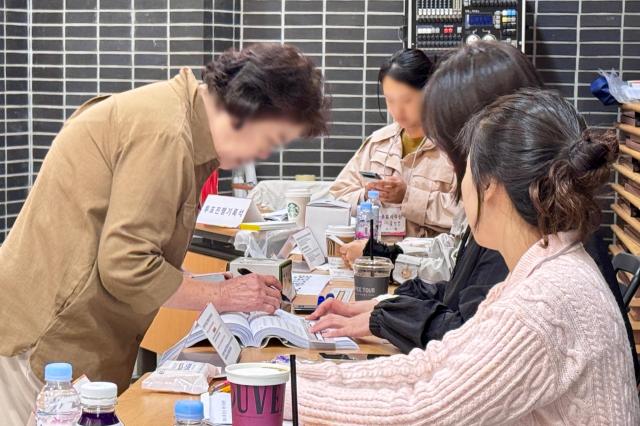 A voter receives a ballot at a polling station in Seoul on Oct 16 2024 AJP Kim Dong-woo