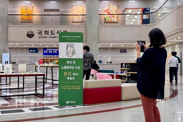 A visitor takes a photo at the special exhibition for author Han Kang at the National Assembly Library in Seoul on Oct 16 2024 AJP Kim Dong-woo