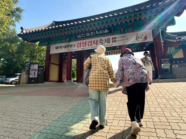 Visitors walk towards the entrance of the Korea kimchi-making for the winter Festival in Namsangol Hanok Village Seoul Oct 6 2024 AJP Han Jun-gu