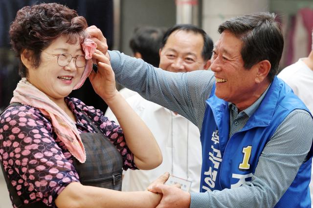 13일 오전 전남 곡성기차마을전통시장에서 10·16 곡성군수 재선거에 출마한 더불어민주당 조상래 후보가 상인의 땀을 닦아주고 있다 사진연합뉴스