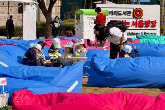 Children read books at the Seoul Outdoor Library in Seoul City Hall Plaza on Oct 17 2024 AJP Kim Dong-woo