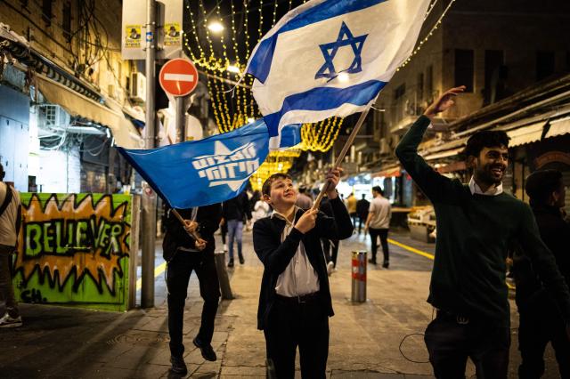 People wave an Israeli flag after the Israeli military confirmed the death of Hamas leader Yahya Sinwar in Jerusalem Israel on Oct17 2024