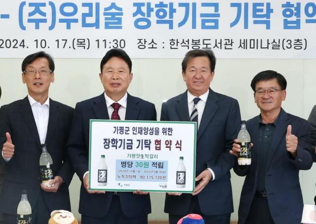 서태원 가평군수왼쪽 두번째와 박성기 우리술 대표세번째가 지난 17일 한석봉도서관에서 열린 장학기금 기탁 협약식에서 기념촬영을 하고 있다사진가평군