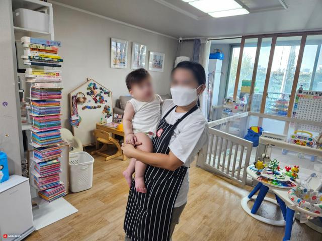  A domestic worker takes care of a baby in an apartment in Seoul Korea on Sep 3 2024 