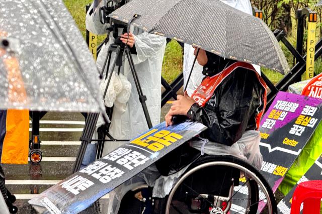 A participant holds a picket sign during a rally for disability rights legislation in front of the National Assembly in Seoul on Oct 18 2024 AJP Kim Dong-woo