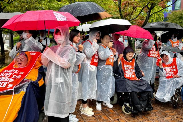 Participants take photos during a rally for disability rights legislation in front of the National Assembly in Seoul on Oct 18 2024 AJP Kim Dong-woo