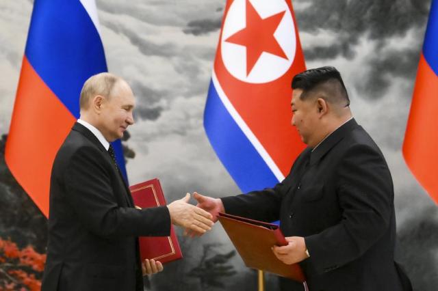 Russian President Vladimir Putin left and North Koreas leader Kim Jong-un exchange documents during a signing ceremony of the new partnership in Pyongyang on June 19 2024 AP-Yonhap