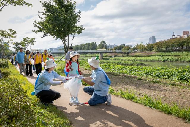 코웨이 임직원과 금천구 자원봉사단이 리버 플로깅 봉사활동을 진행하고 있다 사진코웨이