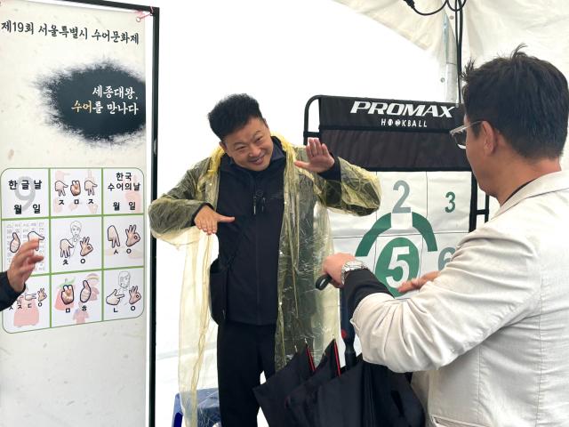 Visitors learn sign language at the 19th Seoul Sign Language Cultural Festival at Gwanghwamun Plaza Seoul Oct 22 AJP Han Jun-gu