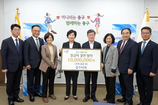 김길성 중구청장오른쪽 네 번째 김정안 중구 전통시장 상권발전소 대표오른쪽 두 번째 정현옥 우리은행 금융소비자보호그룹장왼쪽 네 번째이 관계자들과 기념촬영을 하고 있다 사진우리은행