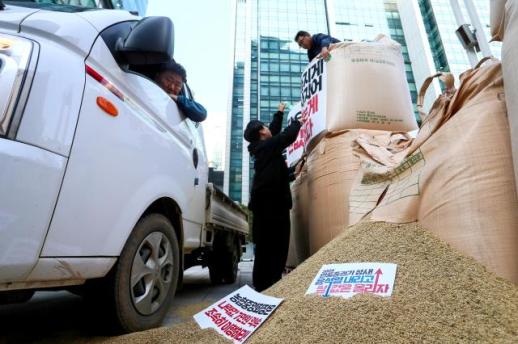 VISUALS: Farmers stack harvested rice in price protest