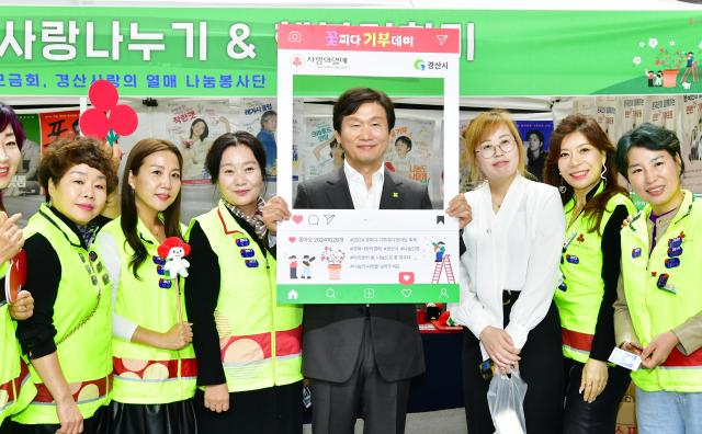 조현일 경산시장이2024 꽃피다 기부데이 한마당 축제에 참석해 자원봉사자들과 기념촬영 하고 있다사진경산시