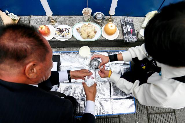 A visitor pours a drink in remembrance at October 29 Memorial Alley in Seoul on Oct 29 2024 AJP Kim Dong-woo