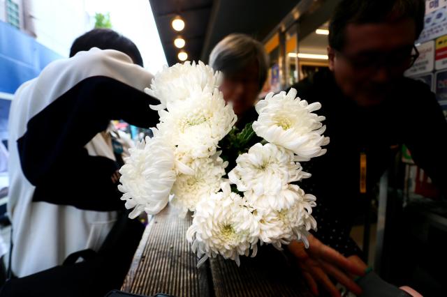 A shop vendor prepares flowers for remembrance at October 29 Memorial Alley in Seoul on Oct 29 2024 AJP Kim Dong-woo