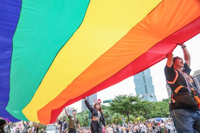 Participants hold a large rainbow flag during the Taiwans annual LGBTQ+ Pride Parade in Taipei Oct 26 2024 AFP-Yonhap