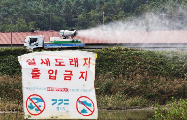 This photo shows a sign saying Do not enter this is a sanctuary for migratory birds and a fumigator spraying sterilizing chemical for the quarantine of highly pathogenic avian influenza HPAI in Yongin Gyeonggi Province Oct 21 2024 Yonhap
