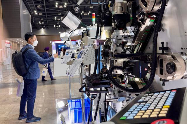 A visitor takes a photo at the Asia Machinery  Manufacturing Exhibition AMXPO at KINTEX in Goyang Gyeonggi Province on Oct 31 2024 AJP Kim Dong-woo