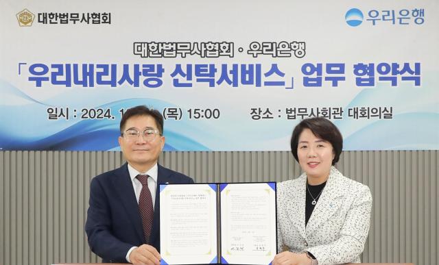 지난 31일 서울 강남구 소재 대한법무사회관에서 우리내리사랑 신탁서비스 업무협약을 체결했다 우리은행 송현주 자산관리그룹장오른쪽과 대한법무사협회 이강천 협회장이 기념촬영을 하고 있다