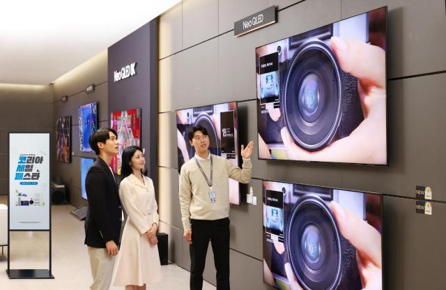 This photo shows a Samsung Electronics manager and models examining products at K-Festa Courtesy of Samsung Electronics