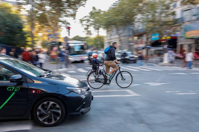 A cyclist rides his bike in a crowded road Paris Oct 23 2024 AFP-Yonhap