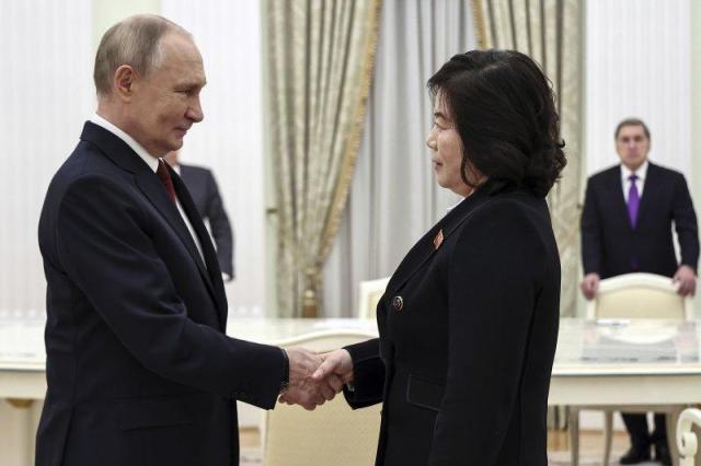 Russian President Vladimir Putin left shakes hands with North Korean Foreign Minister Choe Son-hui during their meeting in Moscow in this photo released by TASS 