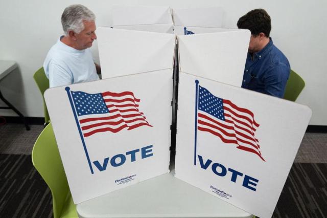 People mark their ballots at the polling place at Tysons-Pimmit Regional Library in Falls Church Virginia on Oct 31 2024 AP-Yonhap