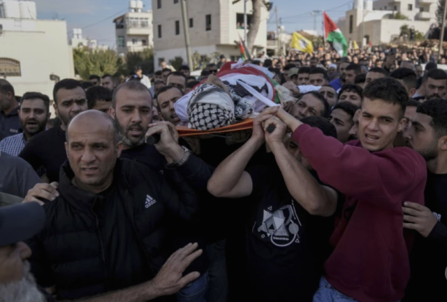 People carry the body of a 16-year-old Palestinian boy killed in Israeli attacks in the West Bank Palestine on Nov 4 2024 AP-Yonhap