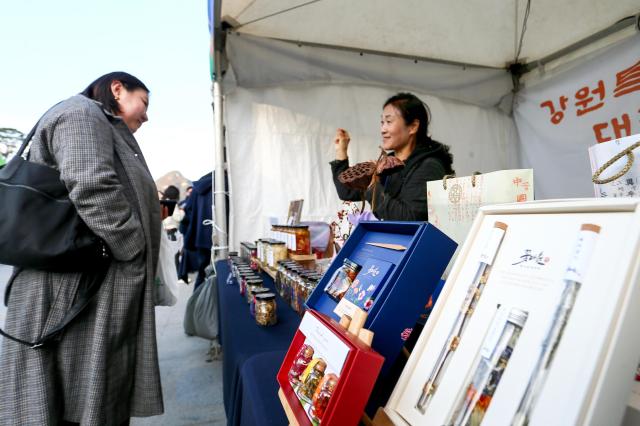 A visitor looks at exhibition booths at the 2024 Small Business Day celebration at Gwanghwamun Square in Seoul on Nov 5 2024 AJP Kim Dong-woo